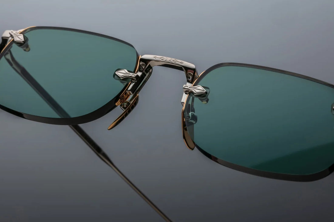 Rimless Jacques Marie Mage sunglasses with teal lenses and a combination of silver and gold hardware