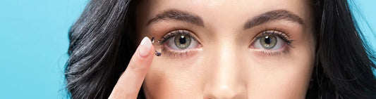 Woman carefully placing a contact lens on her eye, illustrating proper contact lens care
